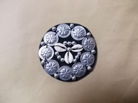 Applikation mit Kaurimuscheln und Münzen